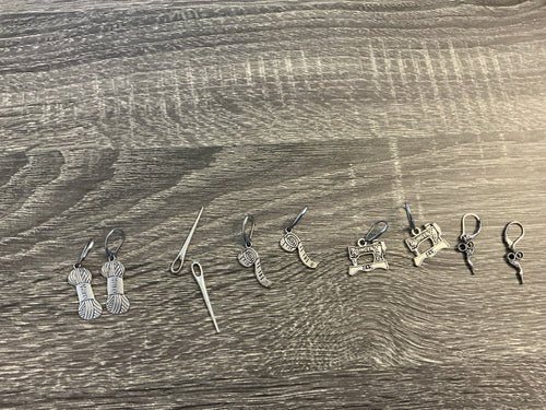 Collection of silver earrings on a wooden surface